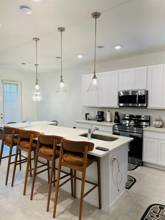646 Longboat Drive Davenport, FL 33896 - Photo 7 of 41 a kitchen with stainless steel appliances kitchen island a white table chairs and a stove