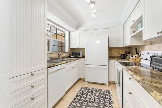 a kitchen with granite countertop cabinets and appliances