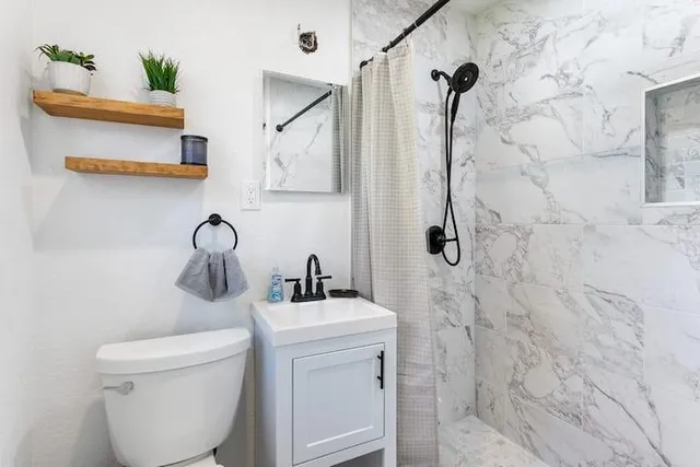 a bathroom with a toilet sink and mirror