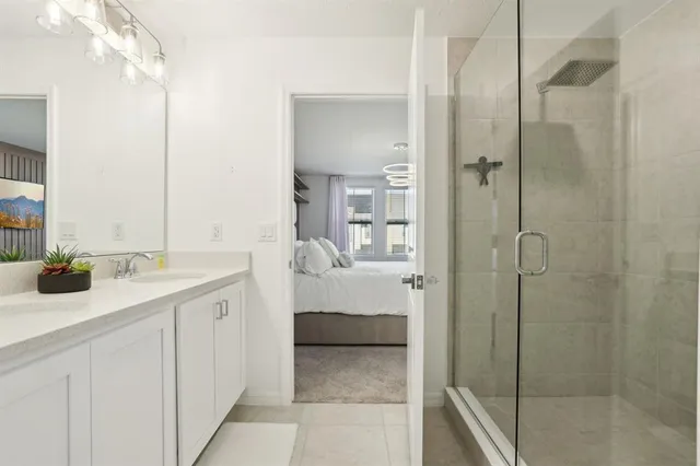 a en suite bathroom with a shower sink and mirror
