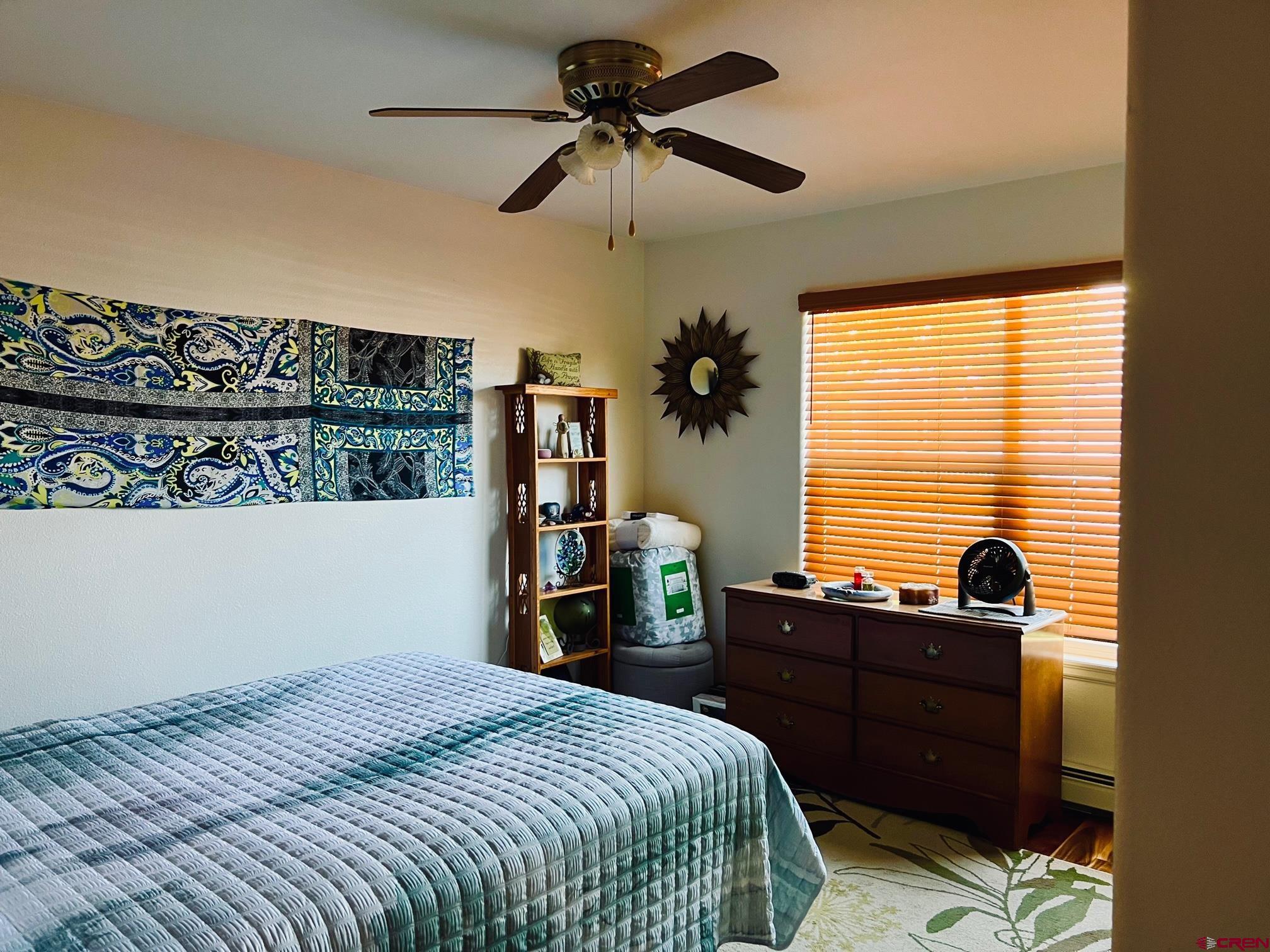 511 Hazel Circle Fruita, CO 81521 - Photo 16 of 24 a bedroom with a bed and a chandelier