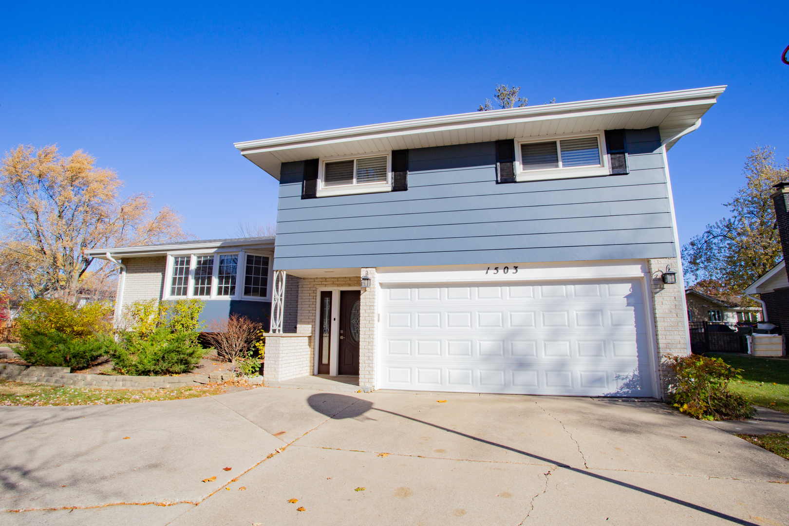 a front view of a house with a yard and a garage