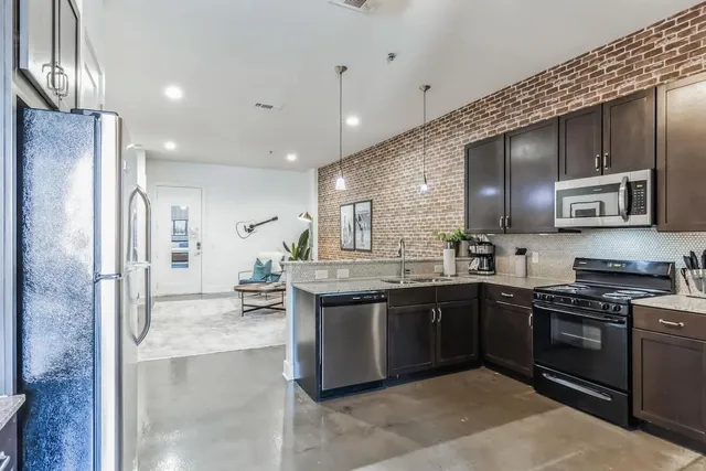 a kitchen with kitchen island a counter top space cabinets and stainless steel appliances
