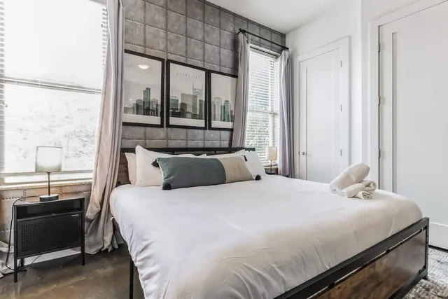 a bedroom with a bed and large window