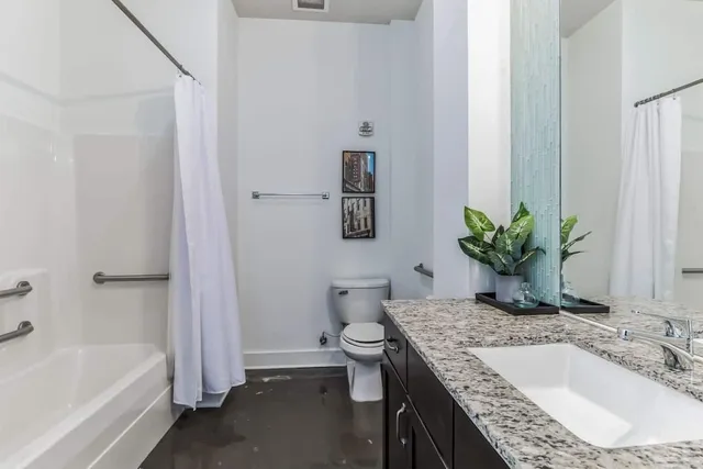 a en suite bathroom with a granite countertop sink and a mirror