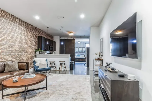 a kitchen with stainless steel appliances kitchen island granite countertop a refrigerator and a stove top oven