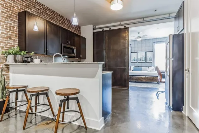 a kitchen with stainless steel appliances granite countertop a sink stove and microwave
