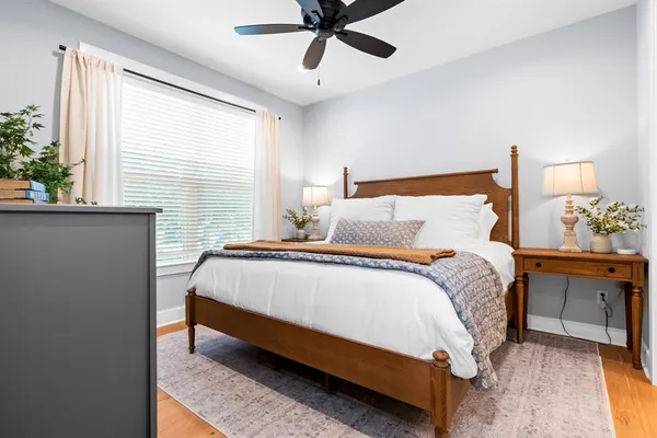 a bedroom with a bed and a lamp on dresser