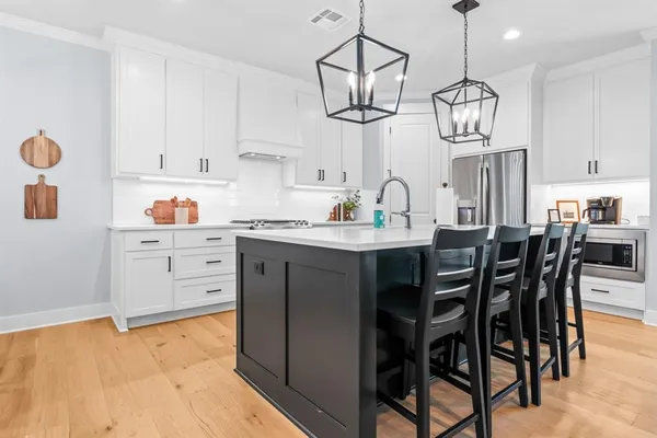 a kitchen with a dining table cabinets and stainless steel appliances