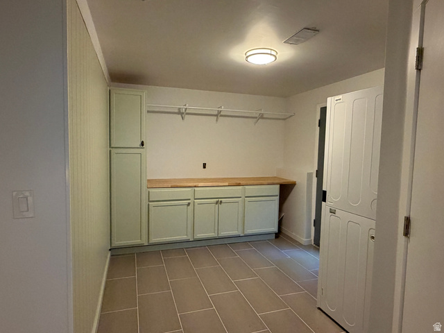 375 East 10560 South Sandy, UT 84070 - Photo 10 of 21 Utility room featuring light green cabinetry with a wood-finish countertop, tile flooring, and integrated laundry appliances
