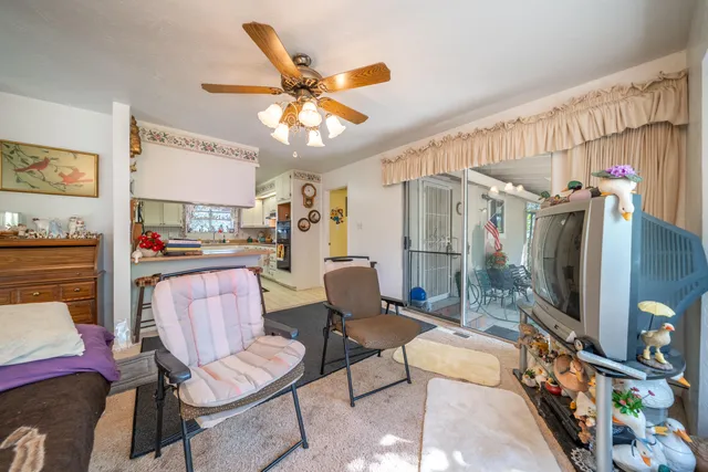 a living room with furniture a flat screen tv and a window
