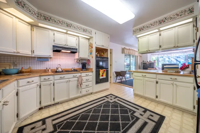 a kitchen with stainless steel appliances a sink stove and cabinets