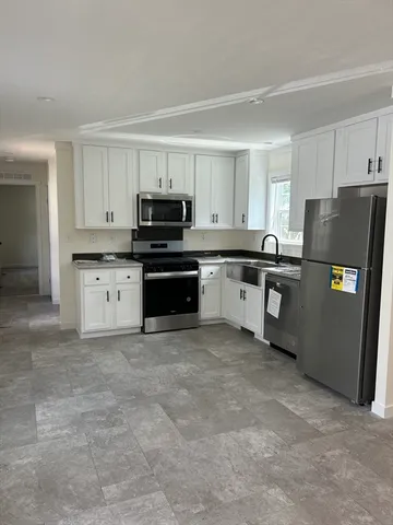 a kitchen with stainless steel appliances granite countertop a refrigerator stove a sink and dishwasher