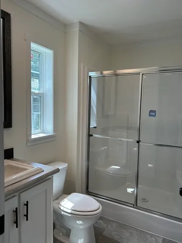 a bathroom with a shower a toilet and a sink