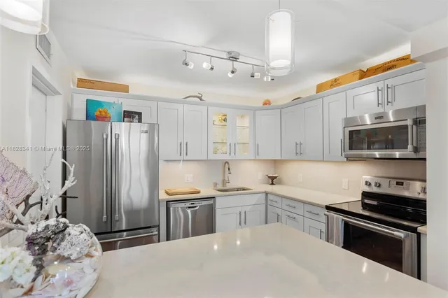 a kitchen with stainless steel appliances granite countertop a refrigerator sink and stove