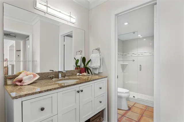 a bathroom with a granite countertop sink a toilet and a mirror