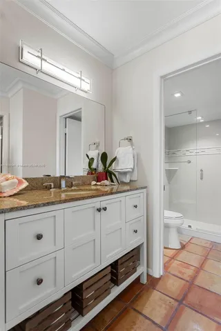 a bathroom with a granite countertop sink mirror and toilet