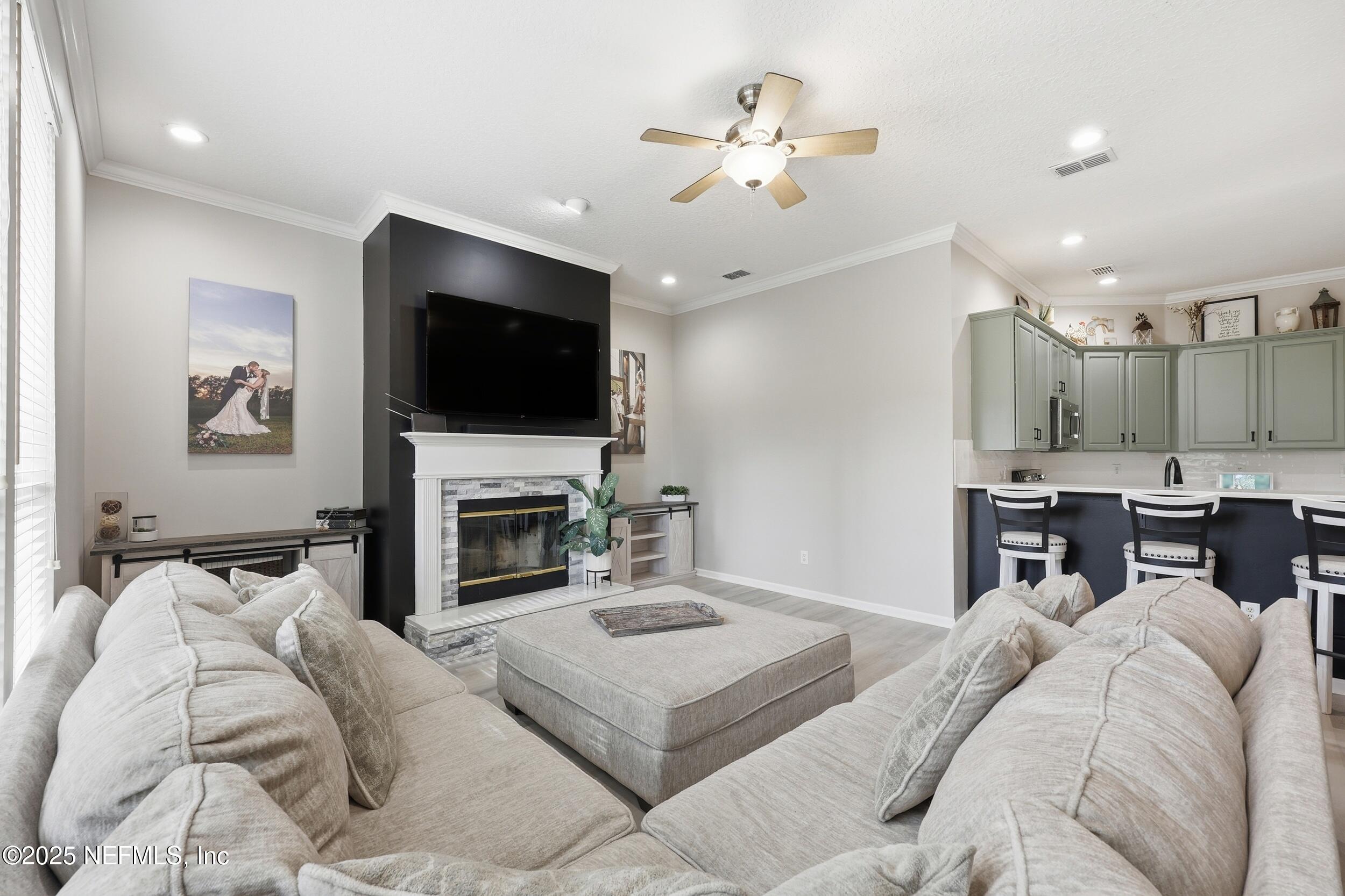 1605 Merroway Lane Ponte Vedra, FL 32081 - Photo 8 of 41 a living room with furniture a fireplace and a flat screen tv