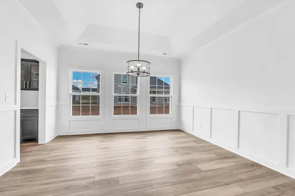 a view of an empty room with wooden floor and windows