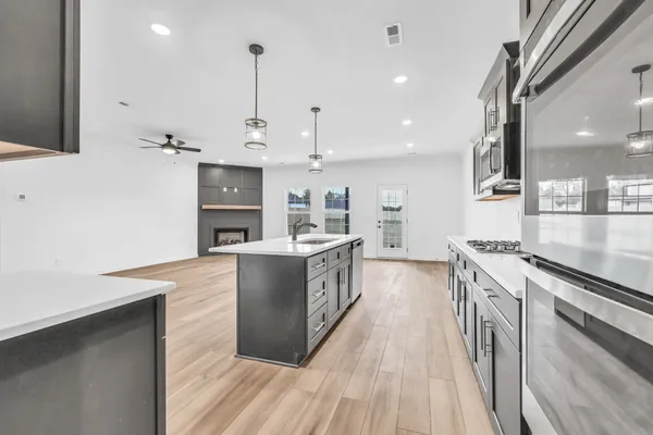 a large kitchen with stainless steel appliances granite countertop a lot of counter tops and a stove