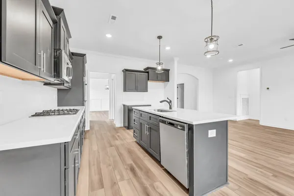 a kitchen with stainless steel appliances granite countertop a sink a stove and a refrigerator