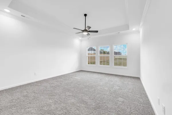 an empty room with windows and ceiling fan
