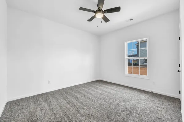 an empty room with a window and a ceiling fan