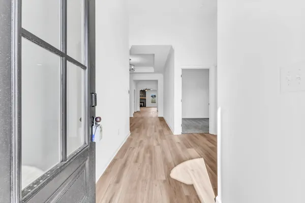 a view of a hallway with wooden floor and staircase