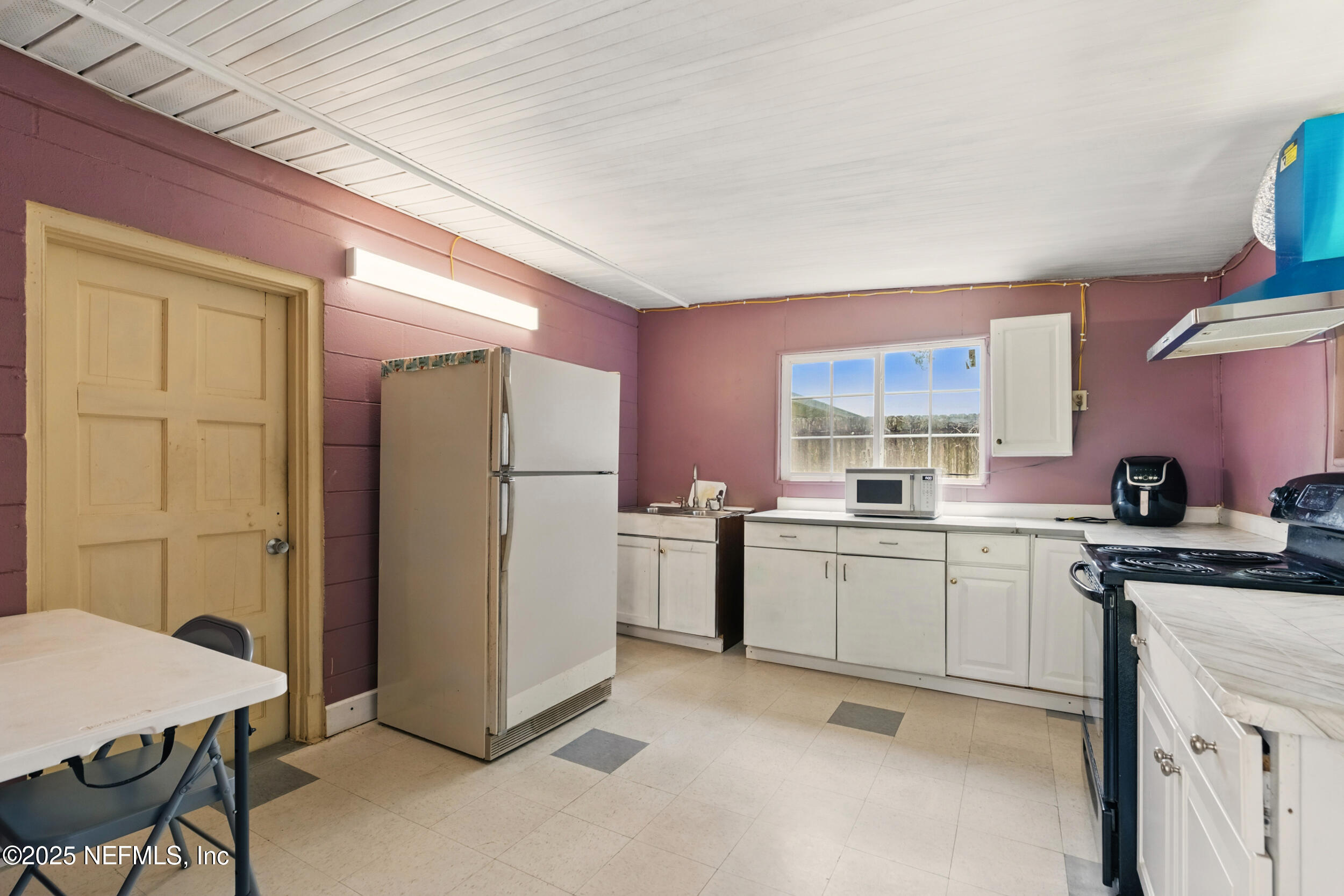 2826 Sam Road Jacksonville, FL 32216 - Photo 24 of 34 a kitchen with a sink stove and refrigerator