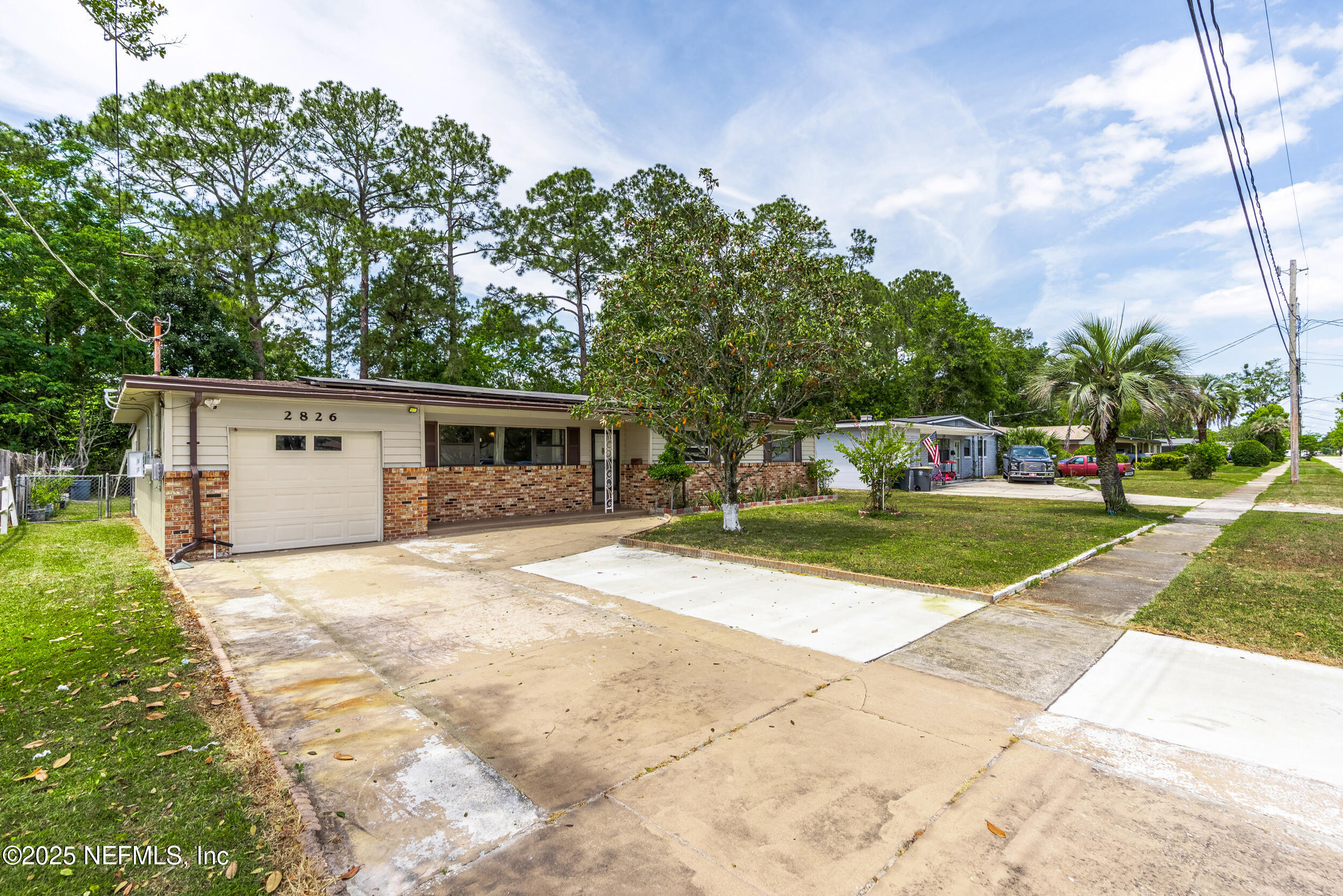 2826 Sam Road Jacksonville, FL 32216 - Photo 4 of 34 a view of a house with a yard and large trees
