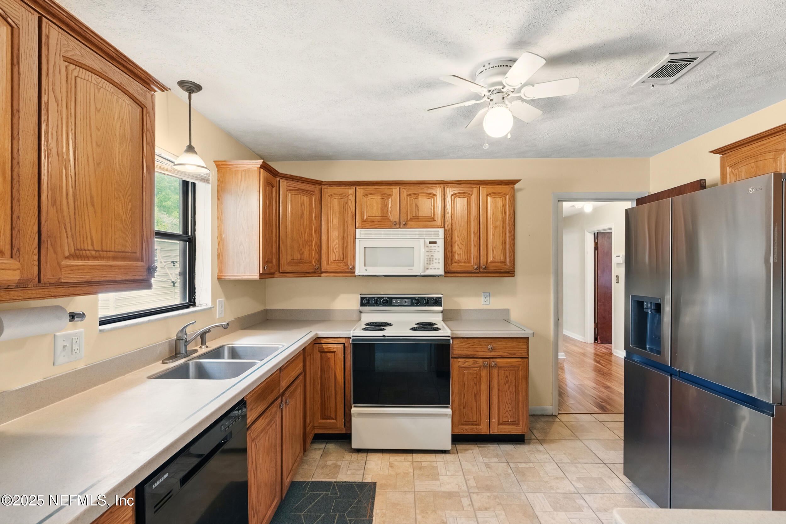 2826 Sam Road Jacksonville, FL 32216 - Photo 9 of 34 a kitchen with a stove sink and refrigerator