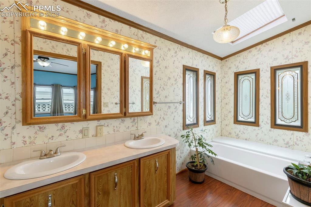 13335 Gymkhana Road Peyton, CO 80831 - Photo 28 of 38 Bathroom featuring a double vanity with wood-finish cabinetry and overhead lighting