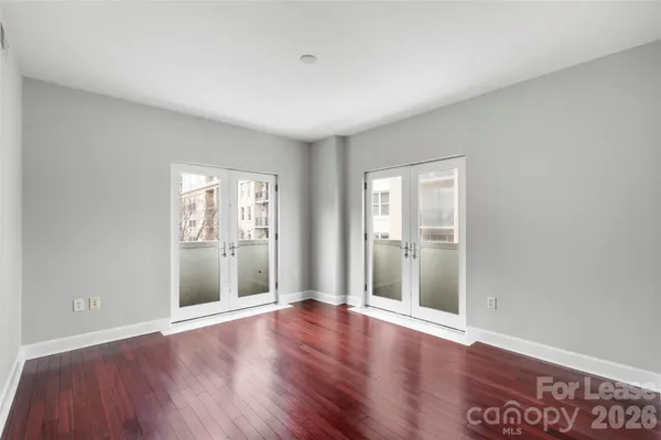 a view of an empty room with wooden floor