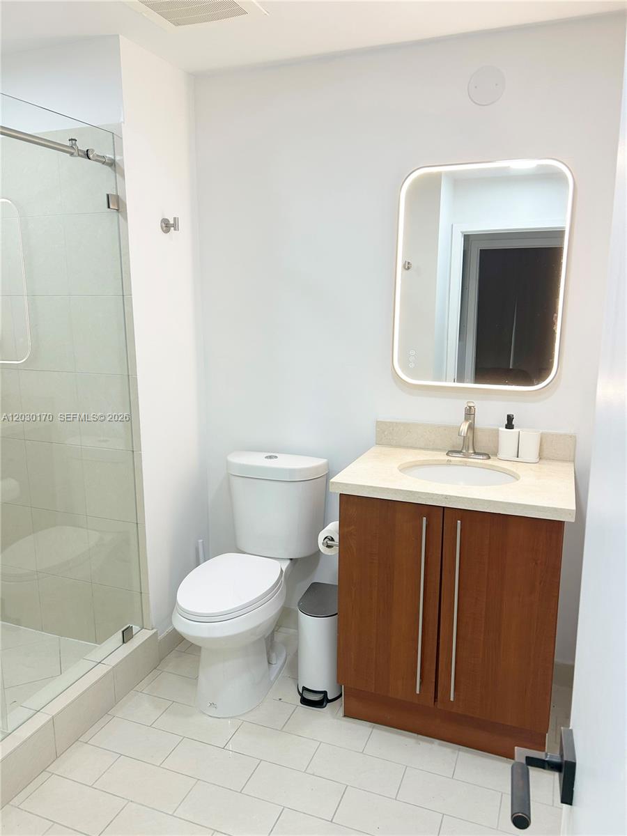 79 Southwest 12th Street, Unit 1710S Miami, FL 33130 - Photo 10 of 25 a bathroom with a sink toilet and shower