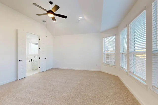 an empty room with a window and a fan