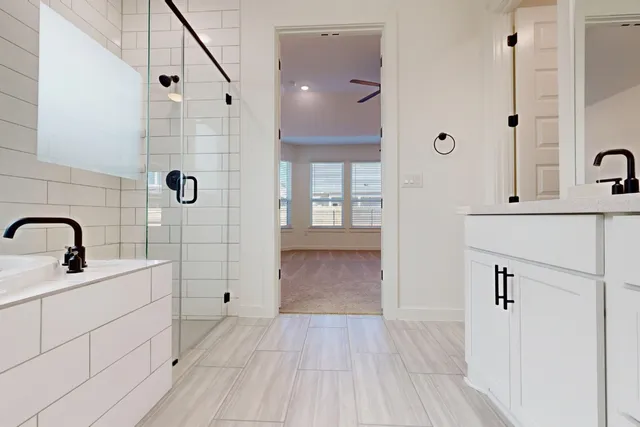 a bathroom with a double vanity sink a mirror and a shower