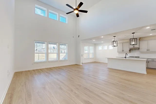 a view of an empty room with window and wooden floor