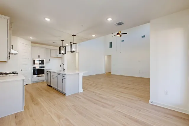a large white kitchen with kitchen island a sink a stove and a refrigerator