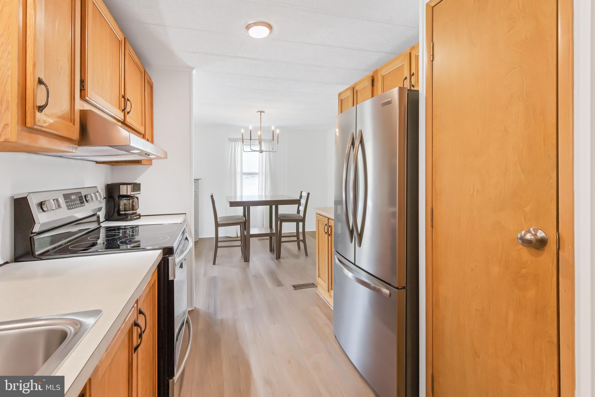 411 Maple Avenue Manheim, PA 17545 - Photo 15 of 35 a kitchen with a refrigerator a stove and a wooden floor