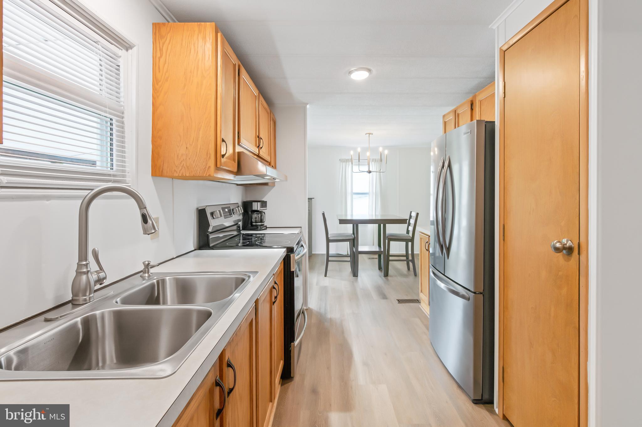 411 Maple Avenue Manheim, PA 17545 - Photo 16 of 35 a kitchen with stainless steel appliances granite countertop a sink a stove and a refrigerator with wooden floor