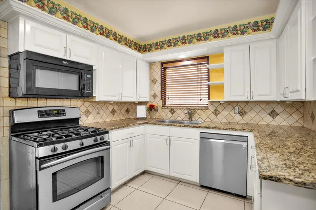 a kitchen with granite countertop cabinets and steel stainless steel appliances