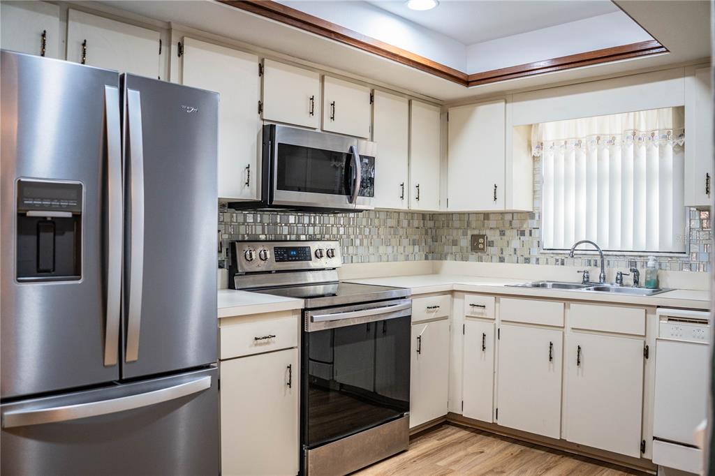 2025 Sylvester Road, Unit AA1 Lakeland, FL 33803 - Photo 3 of 65 a kitchen with cabinets stainless steel appliances a sink and a window