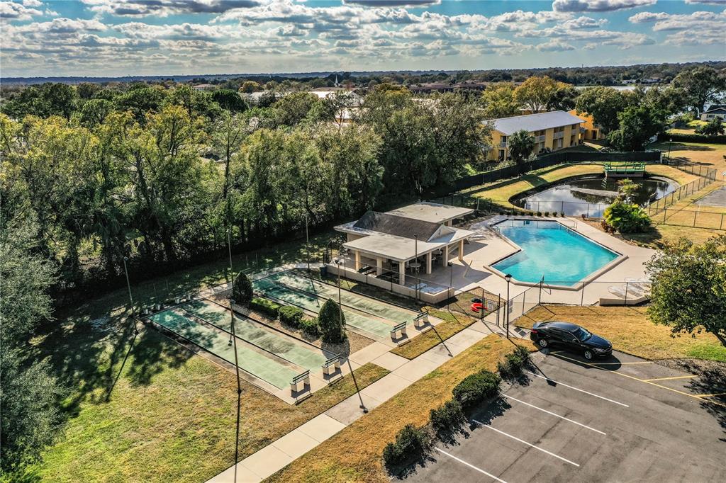2025 Sylvester Road, Unit AA1 Lakeland, FL 33803 - Photo 57 of 65 a view of a swimming pool with lawn chairs under an umbrella