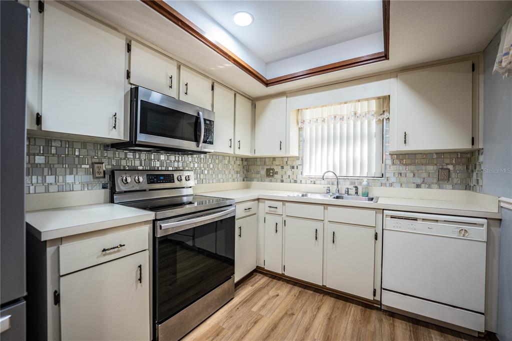 2025 Sylvester Road, Unit AA1 Lakeland, FL 33803 - Photo 6 of 65 a kitchen with cabinets stainless steel appliances a sink and a window