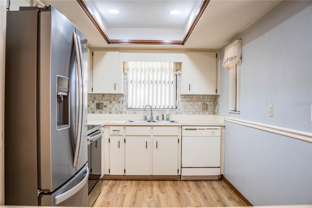 2025 Sylvester Road, Unit AA1 Lakeland, FL 33803 - Photo 9 of 65 a view of a kitchen with white cabinets and wooden floor
