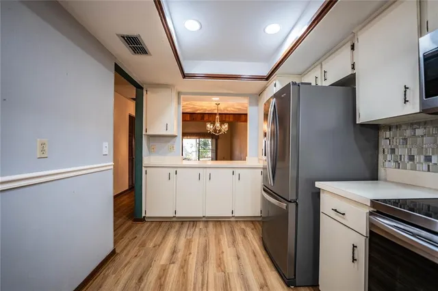 a view of a hallway with wooden floor and cabinet