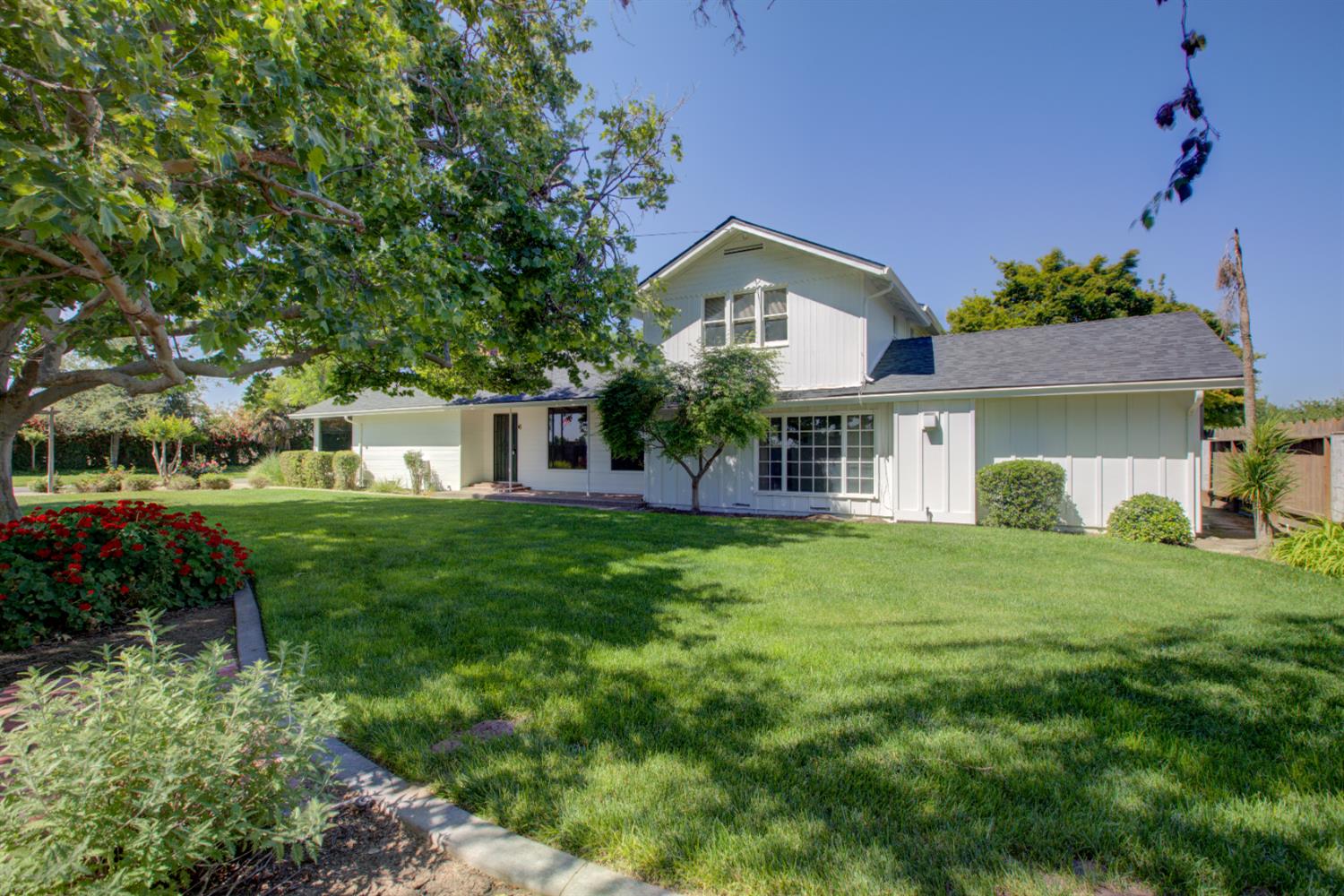 a front view of a house with a yard and trees