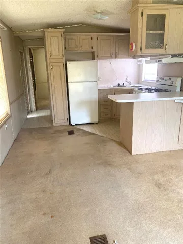 a kitchen with stainless steel appliances a refrigerator a sink a stove a microwave a counter top and cabinets