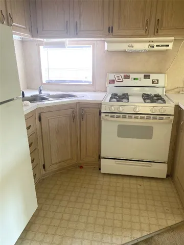 a stove top oven sitting inside of a kitchen