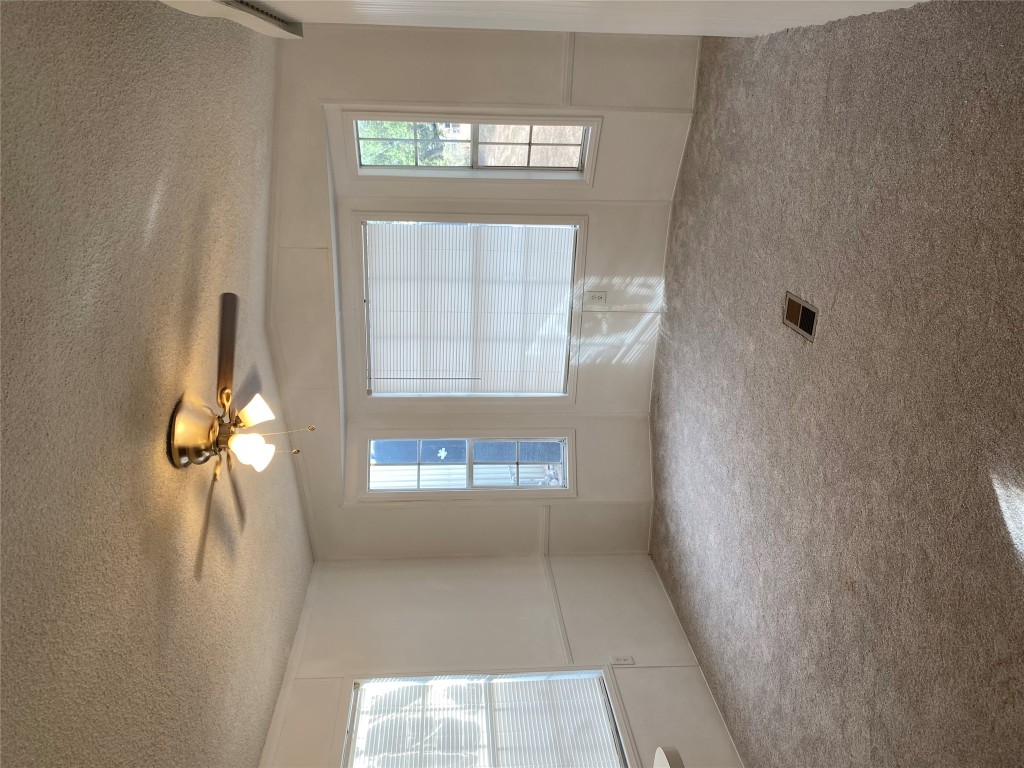 125 Kellar Road, Unit 1 Smithville, TX 78957 - Photo 9 of 18 an empty room with windows and chandelier fan